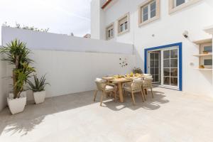 a patio with a wooden table and chairs at Casa da Shaka Baleal in Ferrel