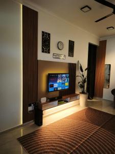 a living room with a flat screen tv on a wall at Anna Homestay Penarik Private Pool in Kampong Ru Sepuloh