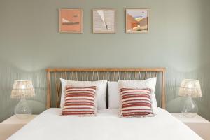 a bedroom with a white bed with three pictures on the wall at Casa da Shaka Baleal in Ferrel +28 photos