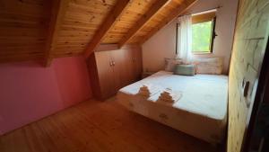 a bedroom with a bed in a room with wooden ceilings at The Mountain Attic in Përmet