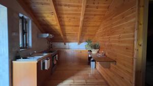 a kitchen with wooden walls and a wooden ceiling at The Mountain Attic in Përmet