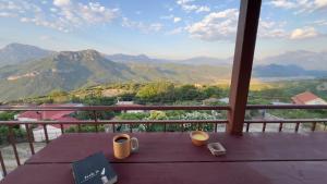 a table on a balcony with a view of mountains at The Mountain Attic in Përmet