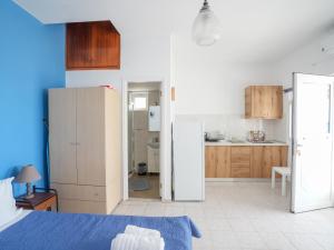 a room with a bed and a kitchen with cabinets at Votsalo in Kardamaina