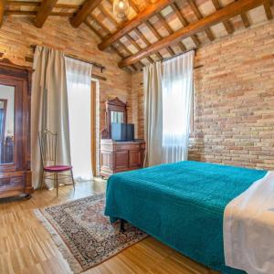 a bedroom with a bed and a brick wall at Terrazza panoramica, 3 camere e 3 bagni in Collecorvino