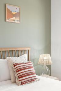 a bedroom with a bed with a lamp and a pillow at Casa da Shaka Baleal in Ferrel