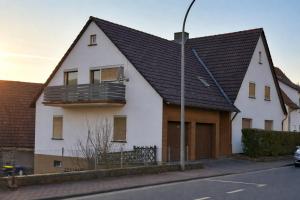 a white house with a black roof on a street at Ferienhaus Werratalsee in Frieda
