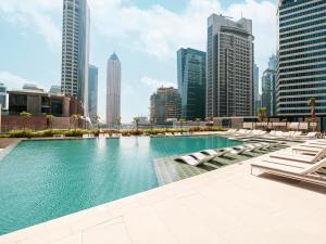 a pool in the middle of a city with tall buildings at Peninsula One Suites by Prestige Nest in Dubai