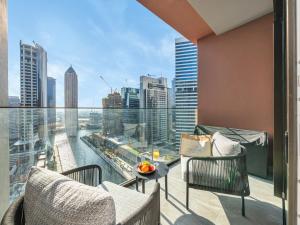 a balcony with chairs and a view of a city at Peninsula One Suites by Prestige Nest in Dubai