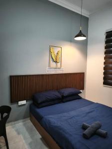 a bedroom with a bed with blue sheets and a chair at Anna Homestay Penarik Private Pool in Kampong Ru Sepuloh +11 photos