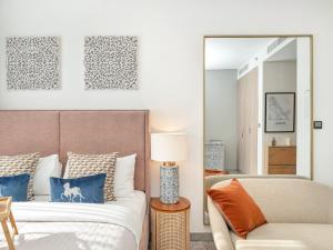 a bedroom with a bed and a mirror at Peninsula One Suites by Prestige Nest in Dubai +42 photos