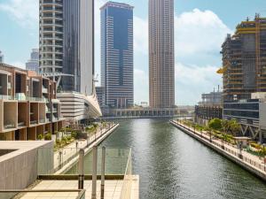 a river in the middle of a city with tall buildings at Peninsula One Suites by Prestige Nest in Dubai