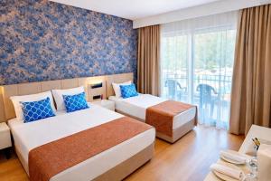 a hotel room with two beds and a balcony at Alder Garden Resort -Ultra All Inclusive in Kemer +102 photos