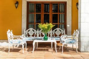 a table with three chairs and a vase with a plant at Casa cerca Playa Cuevas del Mar Llanes - River in Llanes