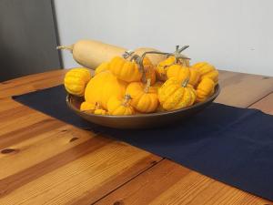 a bowl of yellow pumpkins on a wooden table at Bula Bista 3 double rooms in Southampton