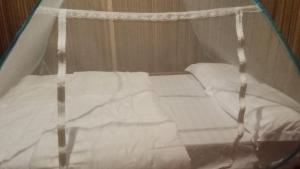 a canopy bed with white sheets and pillows at Sawinsrom Homestay in Fam