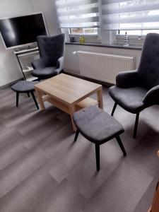 a living room with two chairs and a coffee table at FeWo Waldblick in Goslar