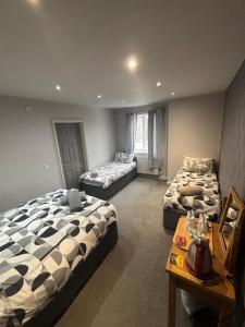 a room with two beds and a table in it at Airport Tavern Accommodation in Felton