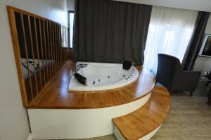 a bath tub in a room with a wooden table at Midis Otel in Edirne +65 photos