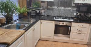 a kitchen with a sink and a stove top oven at Bula Bista 3 double rooms in Southampton