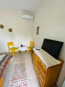 a room with a tv and two chairs and a table at Maison Bohème Suite Fatima in Midoun