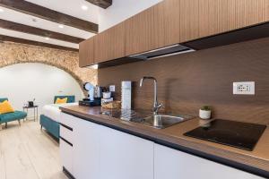 a kitchen with a sink and a bed in a room at Arco di Pietra B&B in Crotone