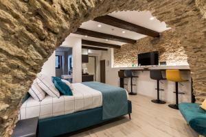 a bedroom with a bed and a stone wall at Arco di Pietra B&B in Crotone