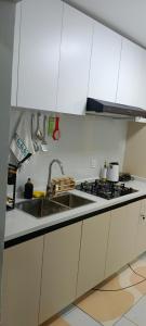 a kitchen with white cabinets and a sink at Elite Homes furnished Studio near JKIA in Syokimau