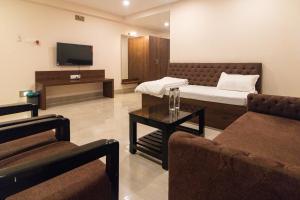 a living room with a bed and a tv at Hotel Sagar Sonnet in Haldia