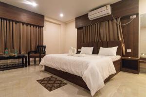 a bedroom with a large bed and a desk at Hotel Sagar Sonnet in Haldia +36 photos