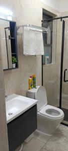 a bathroom with a white toilet and a sink at Elite Homes furnished Studio near JKIA in Syokimau +9 photos