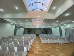 a large room with white chairs and a ceiling at Hotel Nicolás Temuco in Temuco +45 photos