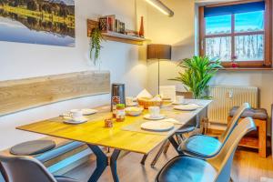 a dining room with a wooden table and chairs at Ferienwohnung Hauzenberg mit Pool & Sauna in Hauzenberg