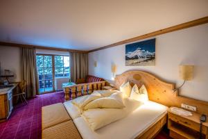 a bedroom with a large bed with a wooden headboard at Pension Berger in Oberlech