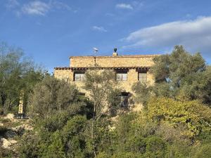 an old building on top of a hill with trees at casa mushin in Useras