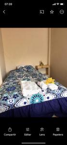 a bed with a blue and white comforter on it at Raimy Sumaq in Arenillas