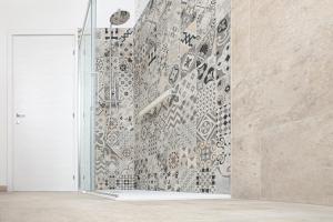 a shower in a room with a mosaic wall at Al Reparo in Pederobba