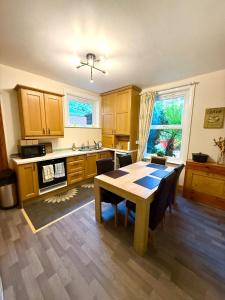a kitchen with a table and a dining room at Coastal Lodge in Leiston