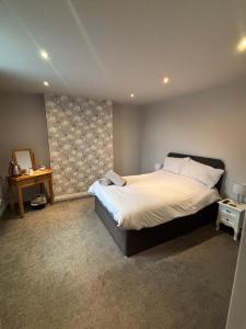 a bedroom with a large bed and a table at Airport Tavern Accommodation in Felton +9 photos