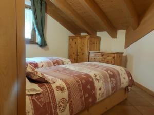 two twin beds in a room with wooden ceilings at Baita al Pian in Bormio