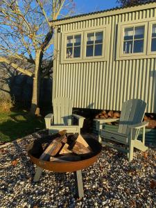two chairs and a fire pit in front of a house at Happy Place Shepherds Hut in Bishops Tachbrook +14 photos