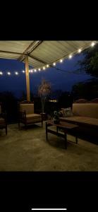 a patio with couches and a table and lights at Raimy Sumaq in Arenillas