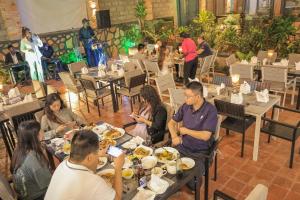 a group of people sitting at tables in a restaurant at The Mist Hotel Entebbe in Kampala