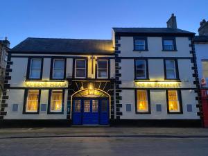 a white building with blue doors on a street at The Queen's Head Hotel in Buxton