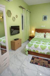 a bedroom with a bed and a flat screen tv at Résidence Gnimakel in Abidjan