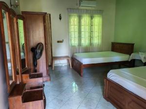 a room with two beds and a mirror at Nice place in Marawila