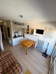a living room with a wooden table and a kitchen at Hirmentaz in Bellevaux
