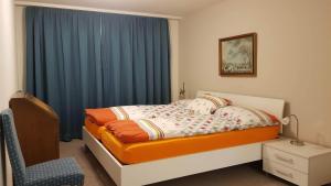 a small bedroom with a bed and a blue curtain at Davos - Cozy Escape - Mountain Rentals in Davos +16 photos