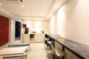 a kitchen with a bar with chairs and a counter at 브라운도트호텔 센텀시티 벡스코점 in Busan