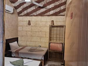 a small room with two beds and a ceiling at Labib Guest house in Aswan