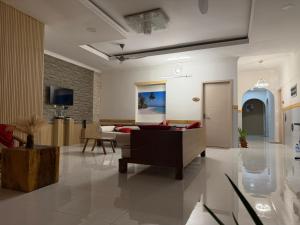 a living room with a couch and a table at Newsy Inn in Hithadhoo +6 photos